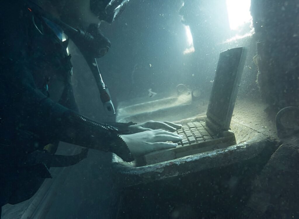 diver-in-a-submerged-and-ruined-airplane-using-laptop img